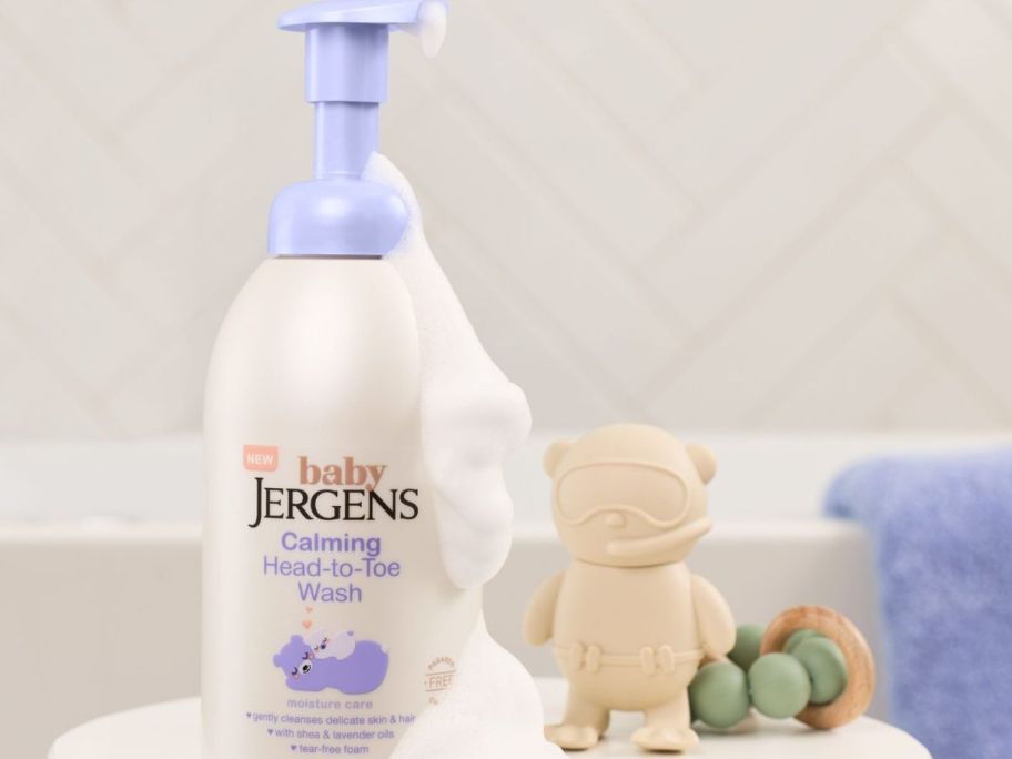 A bottle of Jergen's baby calming wash next to baby toys