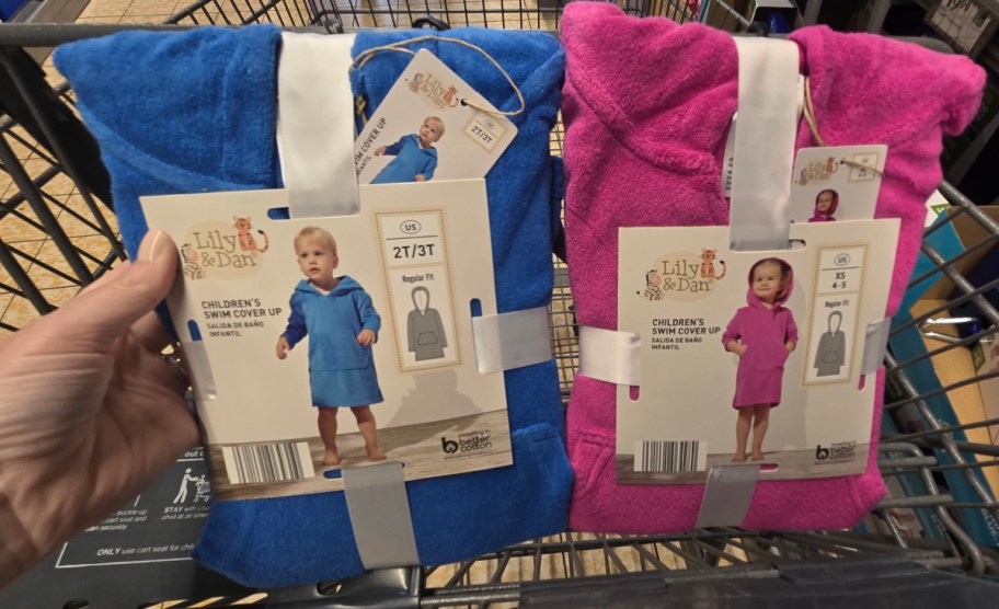 hand holding kids swim coverup displayed insie of shopping cart
