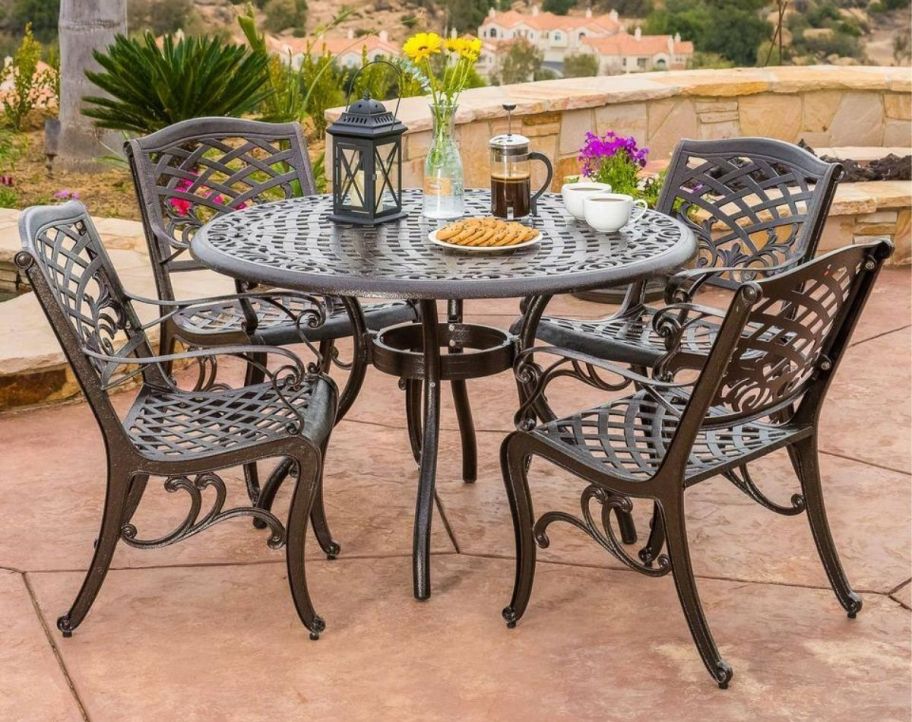a 5 piece metal dining set on a terrace