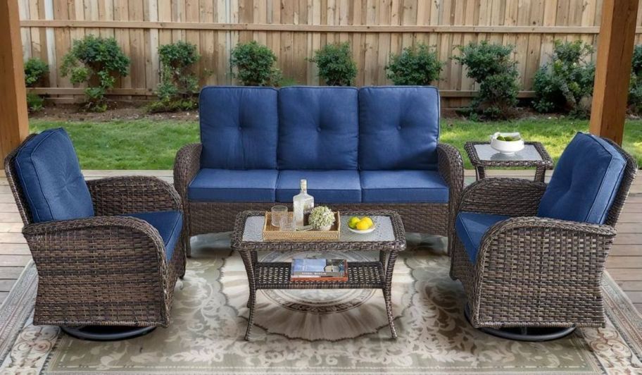a wicker patio set with sofa 2 swivel chairs and a table