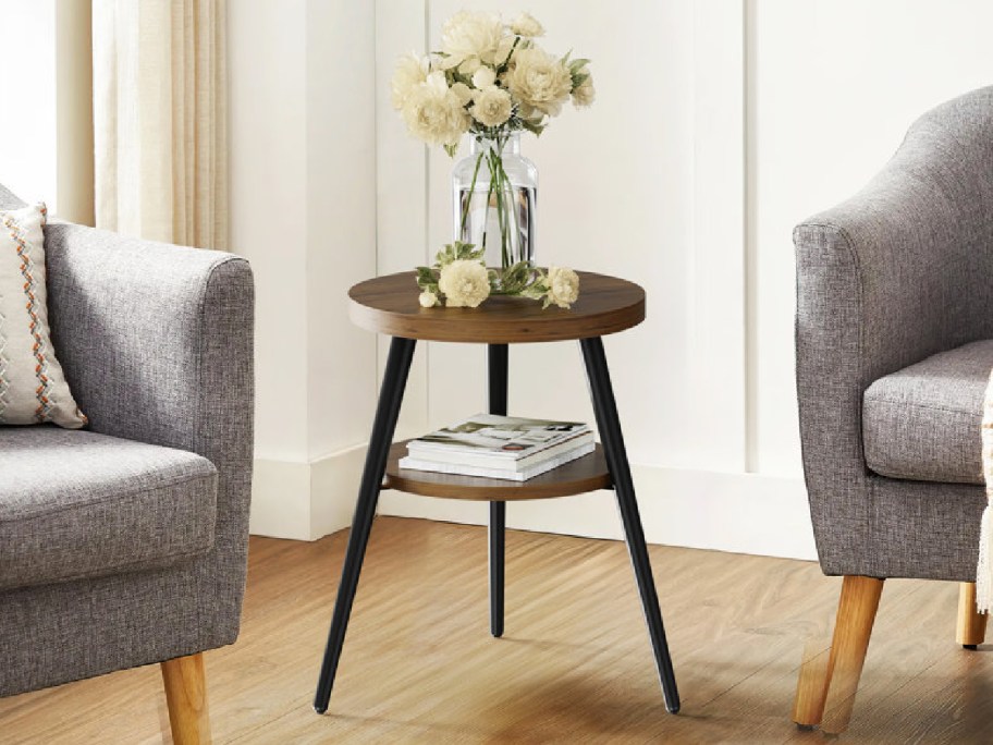 end table with flowers on top and a book at the second tier