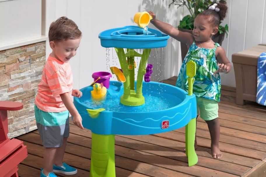 two little kids playing with a 2 tier water table