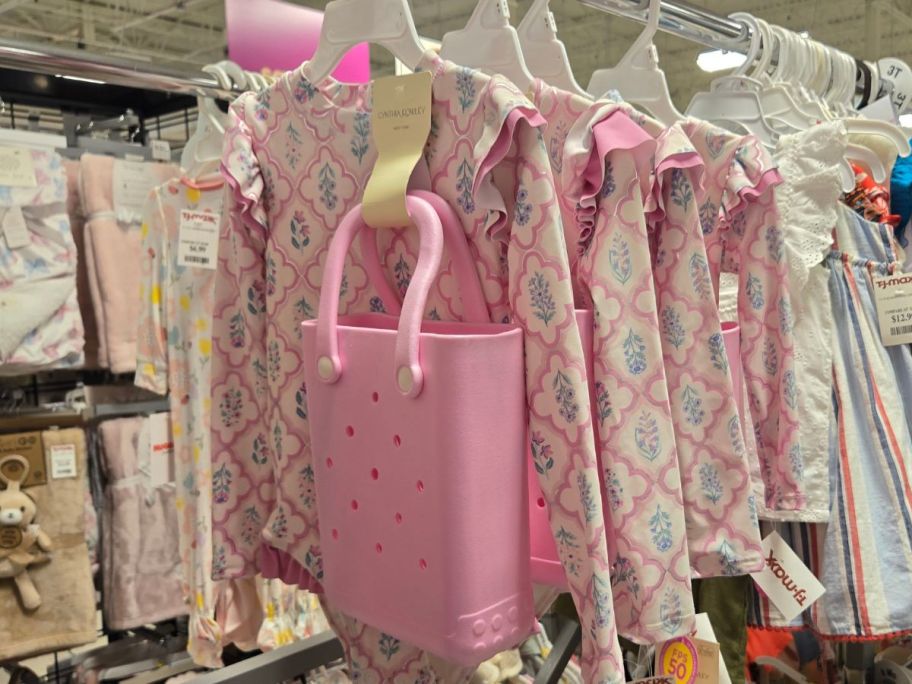 A rack of Cynthia Rowley toddler swimsuits with mini pink Bogg Bag lookalikes