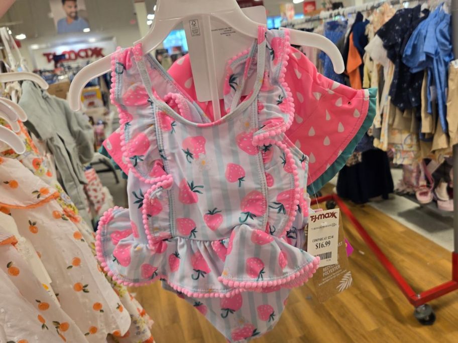 Hand holding a Tommy Bahama Toddler Girl Swimsuit & Hat Set