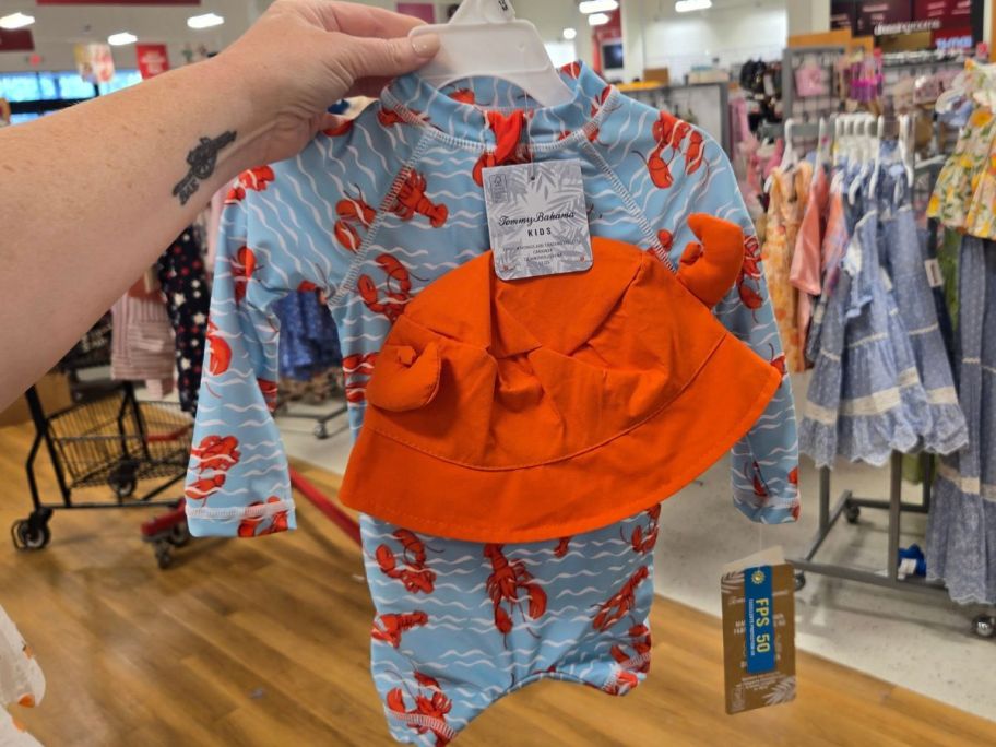 hand holding a tommy bahama swimsuit