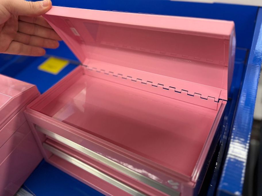 Hand opening the top of a mini tool box at Tractor Supply