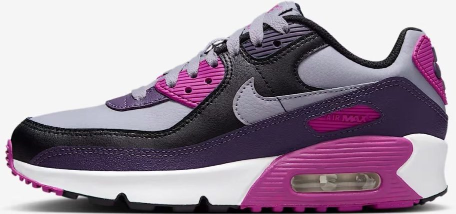 a black, purple and gray kids Nike running shoe