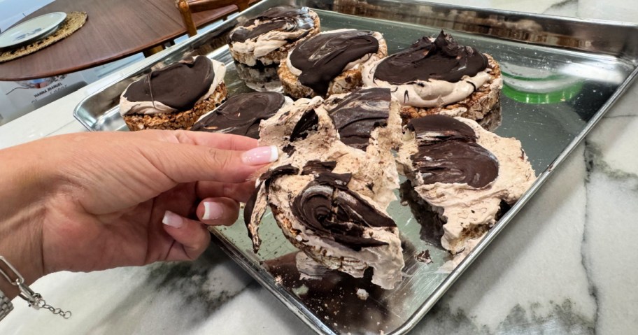 breaking apart frozen protein s'mores on a sheet pan