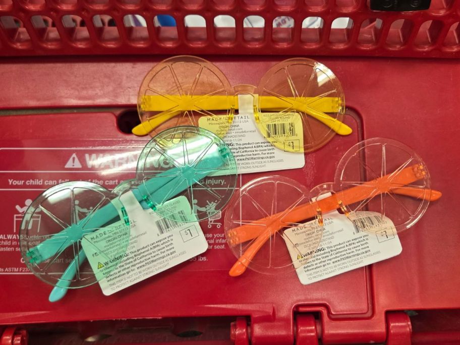 green, yellow, and orange sunglasses in cart in store