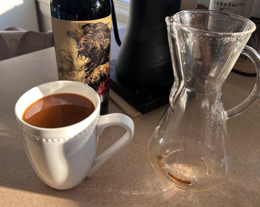 glass coffee container and mug of coffee on counter
