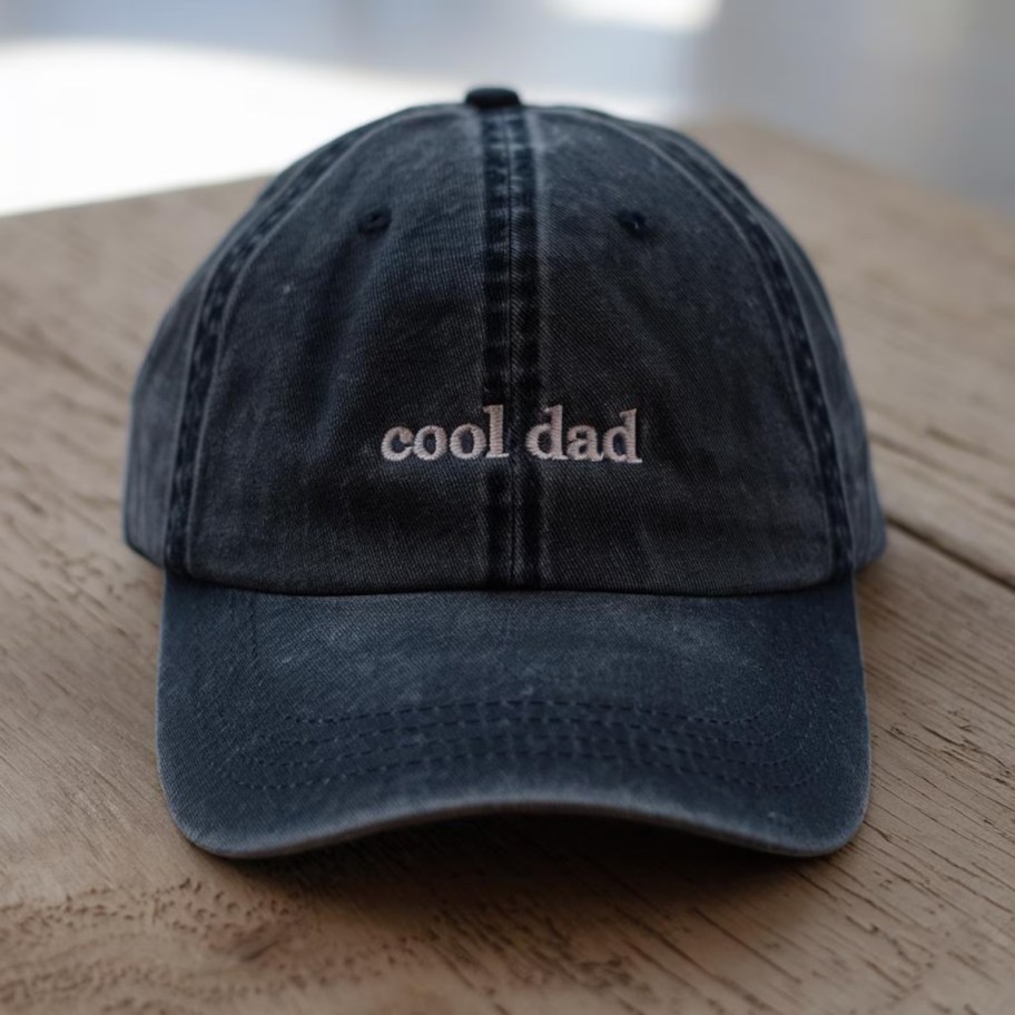 cool dad baseball hat in navy on wood table