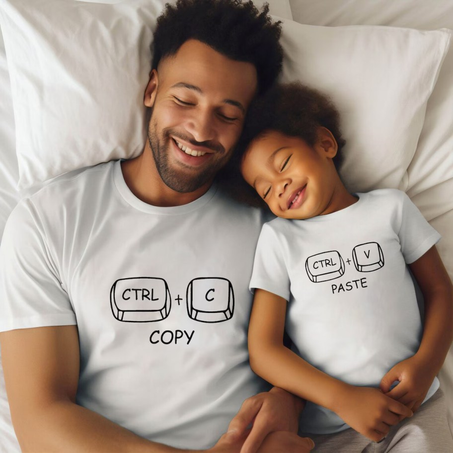 man and son wearing matching copy paste shirts laying on bed