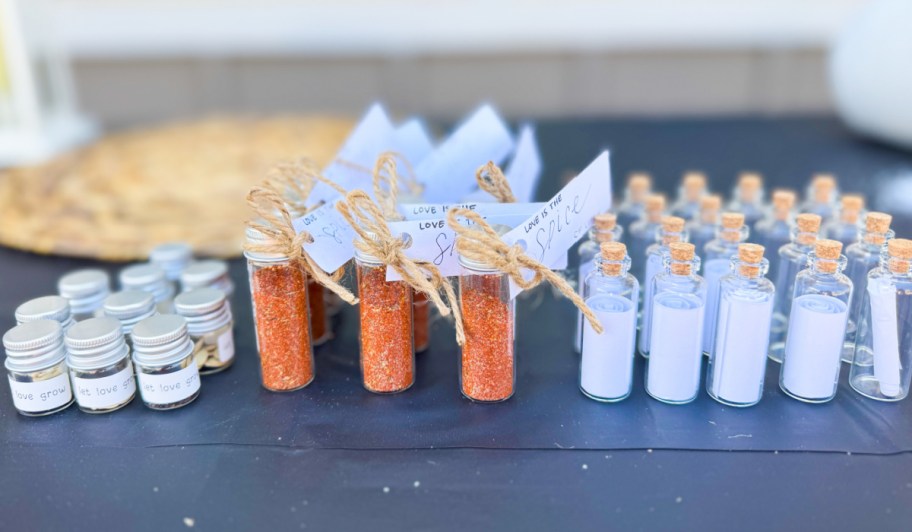 many mini glass bottles with spices and sand inside 