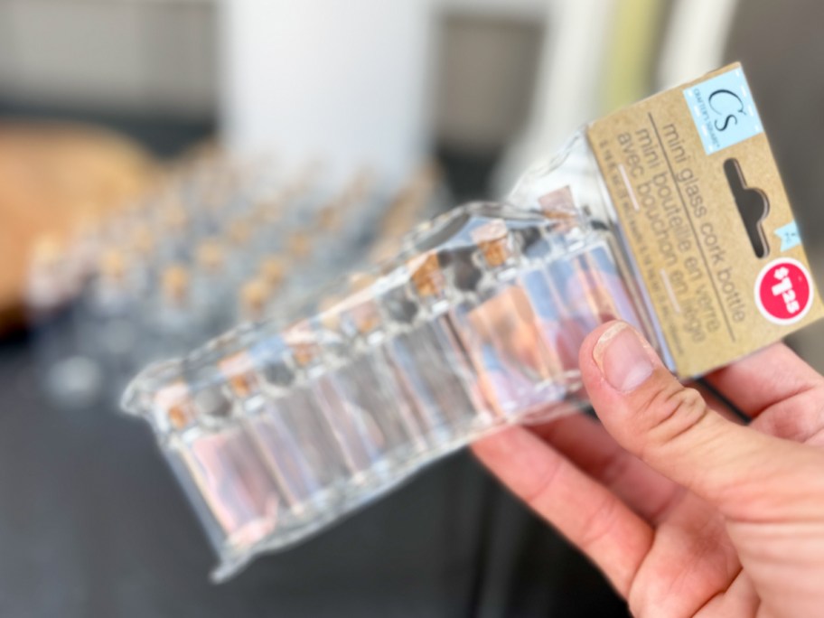 hand holding pack of mini glass bottles 