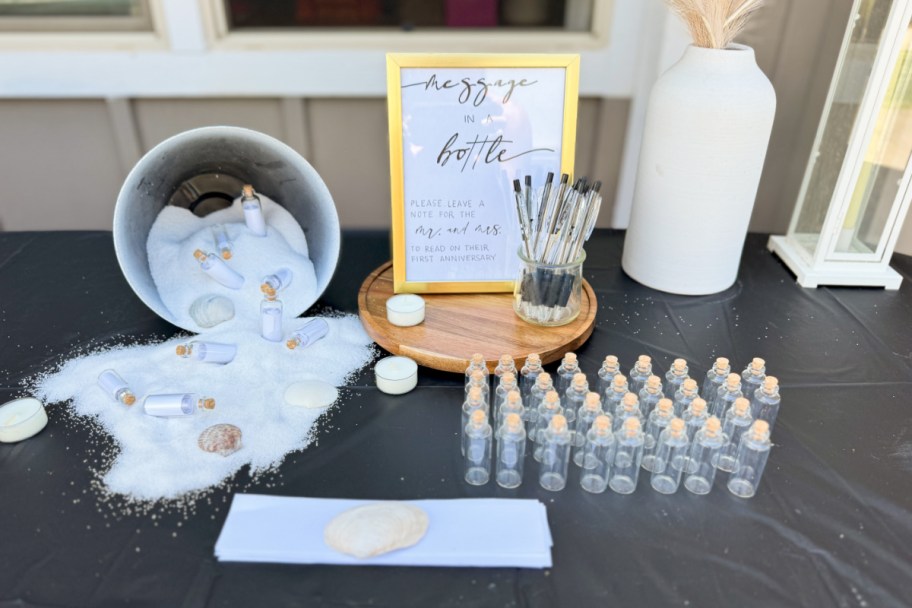 gold frame next to white vase and pot with sand spilling out