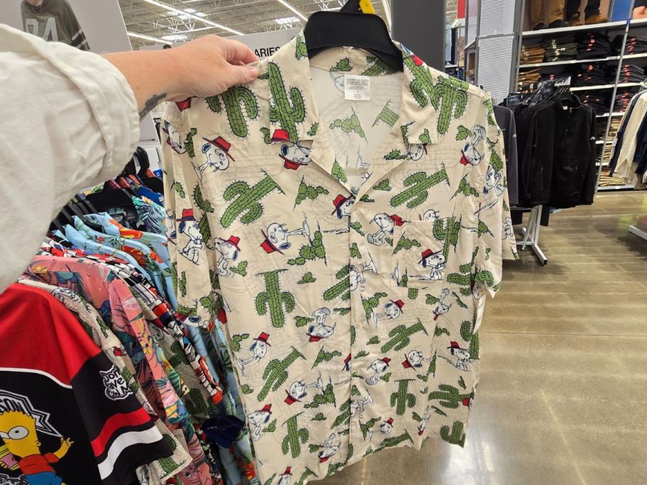 beige and green Snoopy Men's Hawaiian Shirt in hand in store