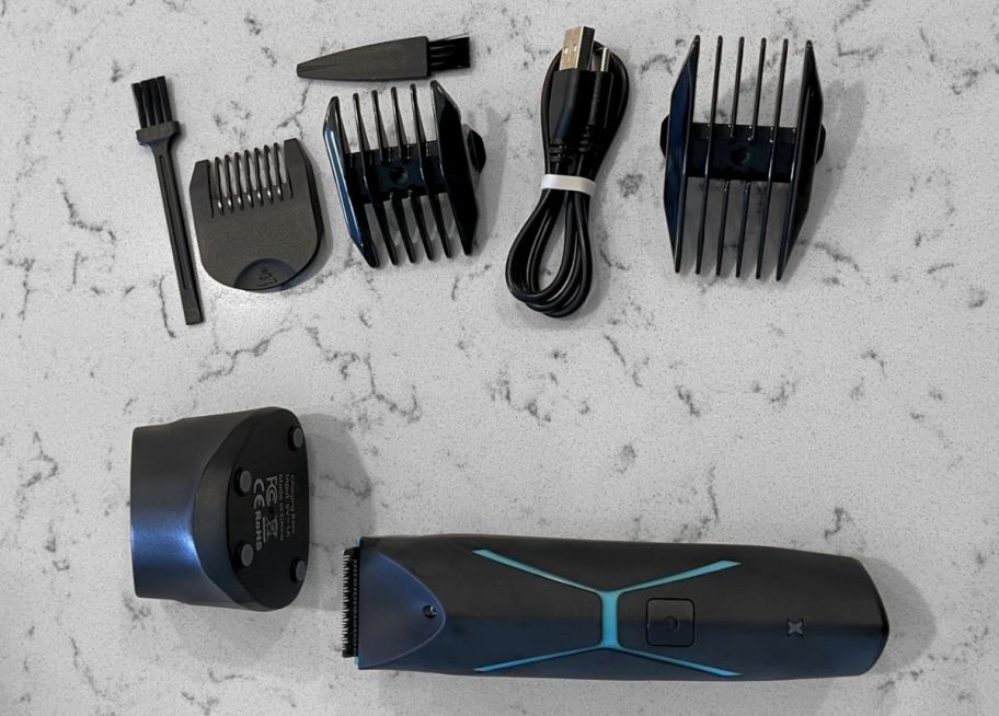 mens electric trimmer shown with blade guards, charging stand, power cord and cleaning brush