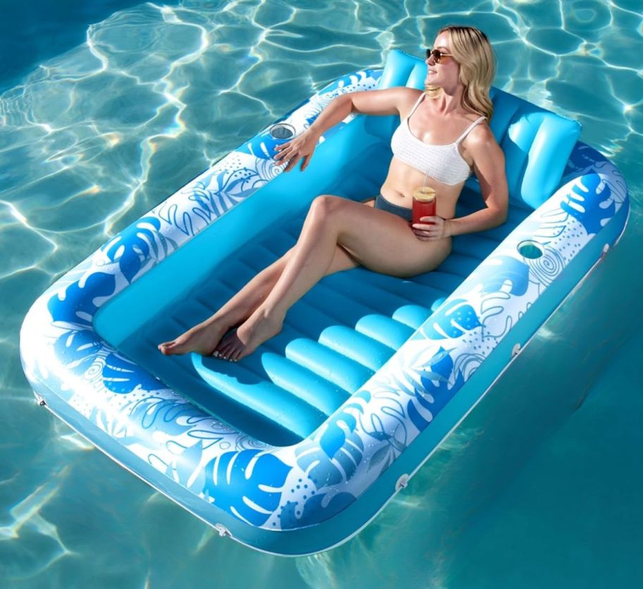 a woman lounging in an inflatable tanning pool