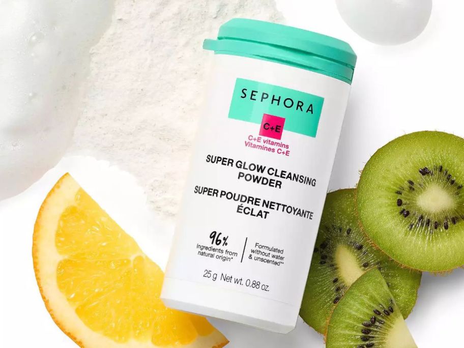 bottle of Sephora Super Glow Cleansing Powder with and orange slice and kiwi slices next to it